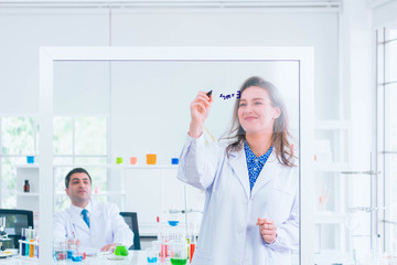 general-view of two people analyzing a citric acid molecular model in a chemistry lab around a lab...