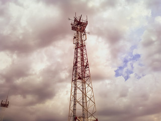 Cellular tower. Telecommunication tower. Communication tower against the sky with clouds.