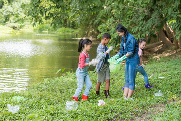 Fototapeta premium asian women and children volunteer help garbage collection charity environment river area. Group of kids school volunteer. Everyone has to help preserve the ecology on earth. (Environment concept)