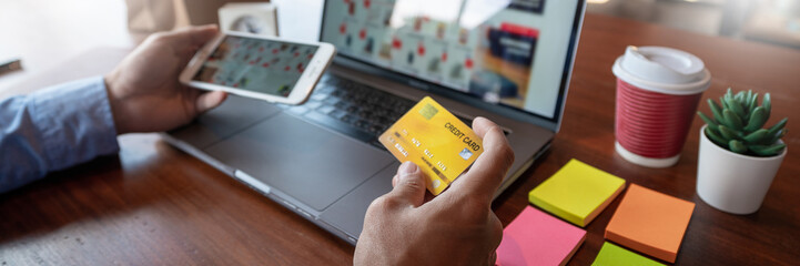 Online shopping credit card data security concept, Hands holding credit card and using smart phone or laptop to shopping or making online payment.