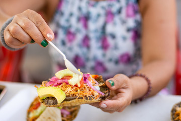 An unrecognizable Woman is eats mexican traditional food called panuchos 