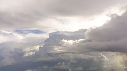 Skyscape view from clear glass window seat of aircraft to cloudscape, traveling on white fluffy clouds and vivid blue sky and sunshine