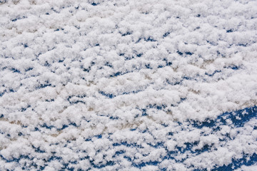 White snow lies on a woolen blue cloth