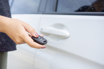 Fototapeta premium hand holding car key, remote control to unlock car door 