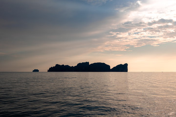 Dramatic Silhouette of mountains in the middle of andaman sea near Phi Phi Islands during sunset.