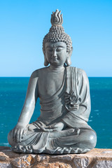 Plaster made Buddha statue in front of the sea
