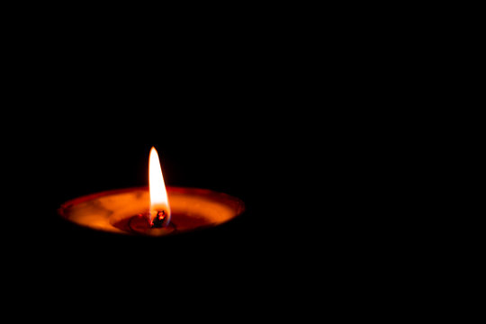 Butterlamp / Wax Candles / Diwali batti / Diya Burning in the dark. One Butter lamp glowing in the dark. selective focus