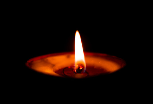 Butterlamp / Wax Candles / Diwali batti / Diya Burning in the dark. One Butter lamp glowing in the dark. selective focus