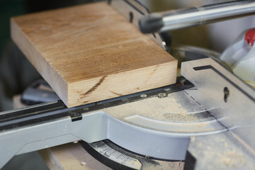 Close-up of wooden detail cutting by electric saw in workshop