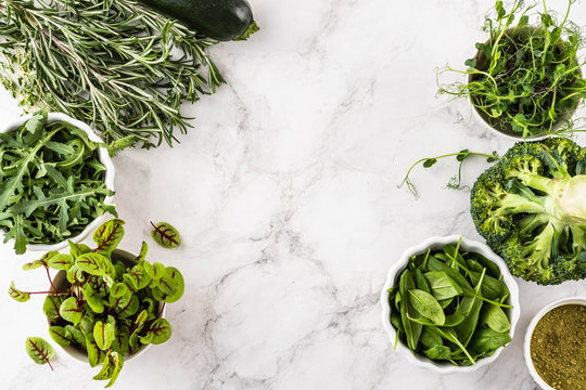 Fresh Green Vegetables Variety On White Background From Overhead, Broccoli, Thyme, Rosemary, Spinach, Microgreens.