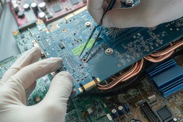 the scientist hands in gloves work with a circuit board in laboratory, close up view