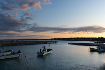 Naklejka premium 朝焼けの海を出港する漁船 北海道初山別村
