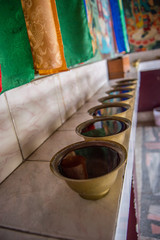 Several bowls of water inside a sacred room at Kapan monastery in Kapan, Nepal