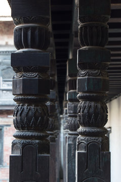A row of black double collumns in a palace in Durbar square in Bhaktapur, Nepal