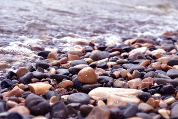 the sea coast in the afternoon with waves and splashes, the sea coast with stones.