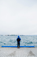 Alone man and calm peaceful sea, Man standing at edge of sea port cloudy foggy winter season