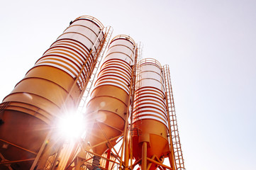 Cement silos of Cement batching plant against evening sun © PixHound