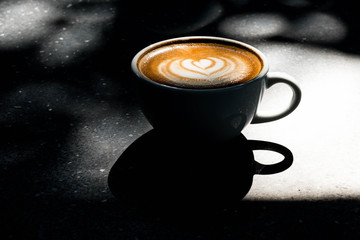 A Latte Coffee art on the marble table in morning.