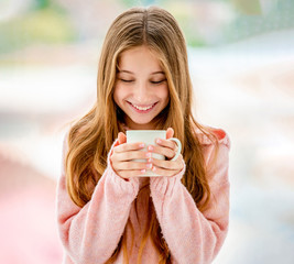 Sweet girl drinking from cup