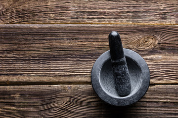 Black mortar with pestle on wooden table