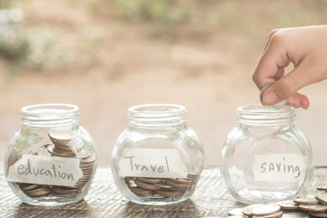 hand of male or female putting coins in jar with money stack step growing growth saving money, coins in glass jar for money saving financial, concept finance business investment