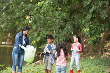 asian women and children volunteer help garbage collection charity environment river area. Group of kids school volunteer. Everyone has to help preserve the ecology on earth. (Environment concept)
