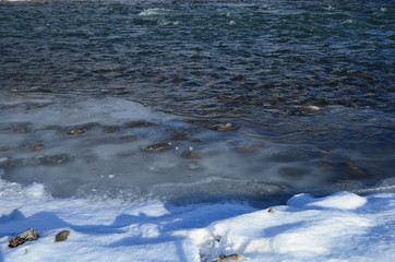 winter landscape in the forest with snow and blue sky and river
