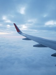 Airplane wing in cloudy sky