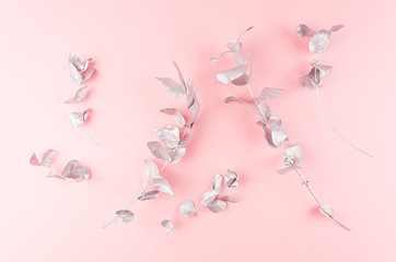 Elegant silver eucalyptus leaves as festive decorative border on soft light pastel pink background,...