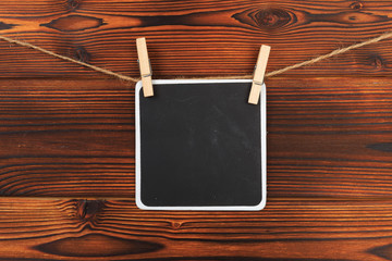 writing board attached to a rope clothespin on wooden background  - Image