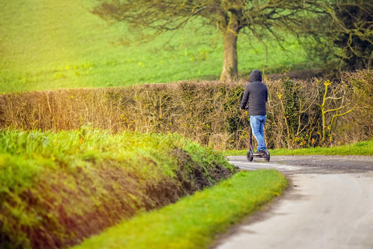 young man strolling with his electric scooter - Powered by Adobe