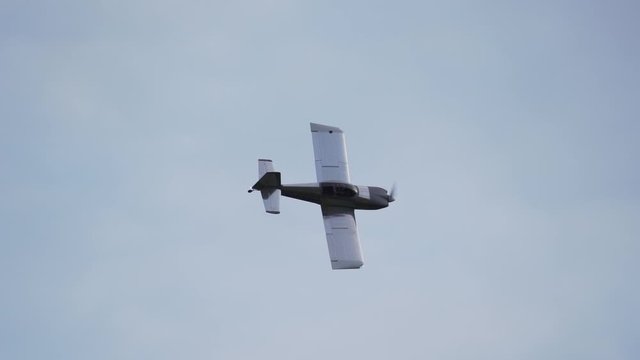 A small homebuilt airplane rolls out of a turn with it's metallic wings reflecting the sky.
