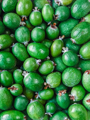 many ripe feijoa fruits top right view - food background