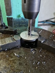 drilling thin round washers made of stainless steel on professional equipment