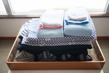 Onsen cloth basket. laundry on floor. Japanese style, Japanese public bathroom that preparing many baskets for clothes changing on the wooden shelf, with some used people clothes.