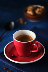 Red Mug of aromatic espresso on a blue table.