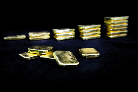 Investment concept of Several pile of gold bars in dark , Fine gold ingot ,Isolated on black background, Selective focus. Financial success, business and wealth concept.