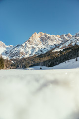 Sunny winter landscape in the nature: Mountain range, snowy trees, sunshine and blue sky