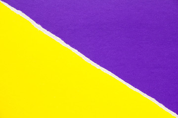 Yellow and purple torn sheet of cardboard paper with diagonal border texture background. Can be...