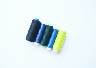 A set of multi-colored sewing threads on a white isolated background.