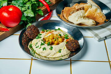 Close up view on tasty Bowl of arabic, israel or lebanese vegetarian hummus made from chickpeas with pita and vegetables Traditional appetizer oriental cuisine