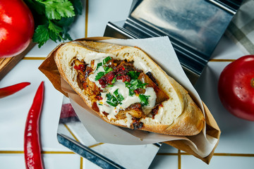 Tasty street food - pita with tomato, onion and sauce, beef burger on a white background. Greek cuisine. Close up view.