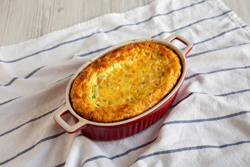 Homemade Cheese Corn Pudding Casserole on cloth, low angle view.