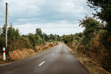 Picturesque country road in Normandy a cloudy day of summer