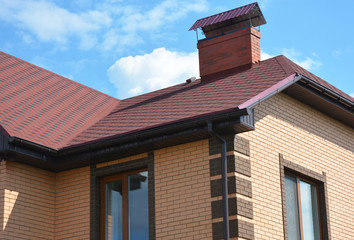 Roofing constraction in house roof corner problem areas. Laying asphalt shingles on house roof corner. Guttering.