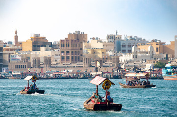 Fototapeta na wymiar Old Dubai view over the creek towards Deira side with traditional water taxi (abra).