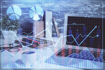 Financial graph colorful drawing and table with computer on background. Double exposure. Concept of international markets.