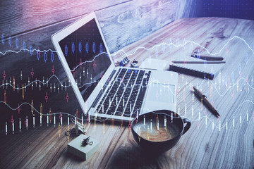 Double exposure of graph and financial info and work space with computer background. Concept of international online trading.