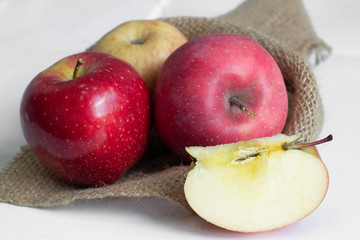 red apples on sackcloth with half of apple
