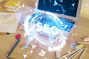 Multi exposure of table with computer and seo drawing hologram. Search optimization concept.